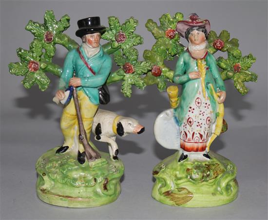 A matched pair of Staffordshire pearlware figures of a sportsman with his dog and a figure of his wide, c.1820